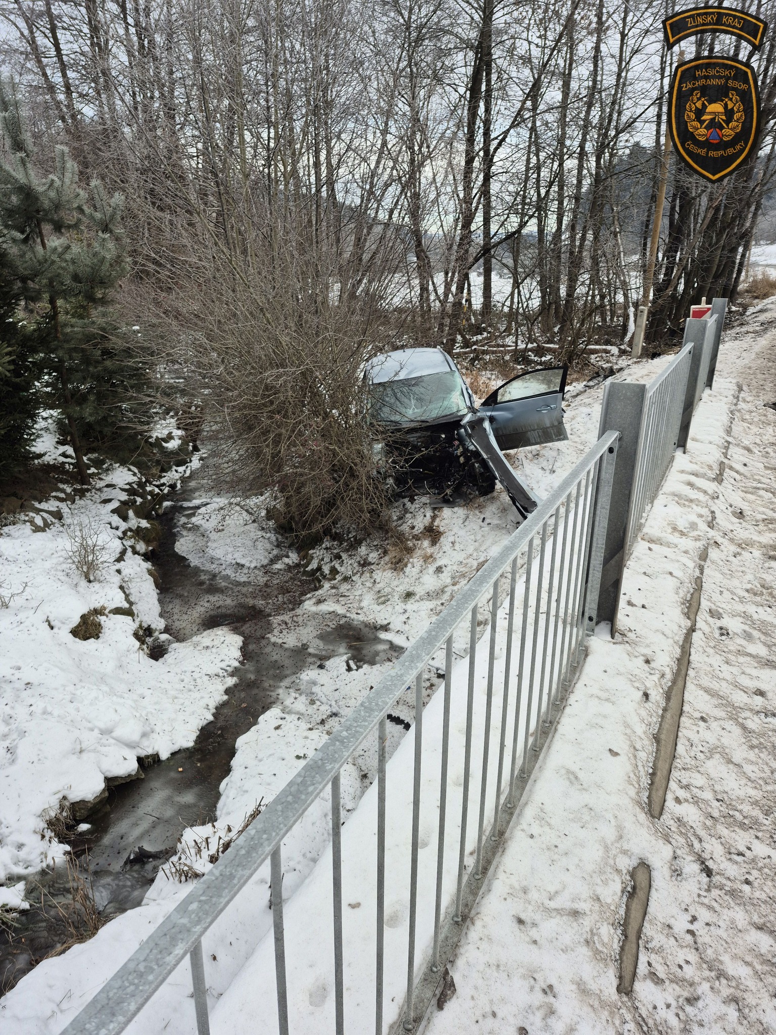 Řidič sjel ze silnice, narazil do vzrostlého stromu a vozidlo následně skončilo u místního potoku.